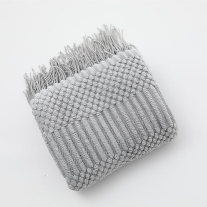 Gebreide plaid met Scandinavisch patroon en franjes over een stoel - lichtgrijs