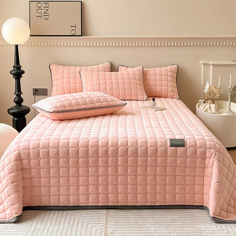 Gewatteerde bedsprei van teddy met blokjesmotief op een tweepersoonsbed - roze