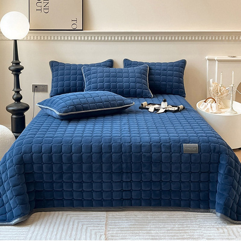 Gewatteerde bedsprei van teddy met blokjesmotief op een tweepersoonsbed - donkerblauw