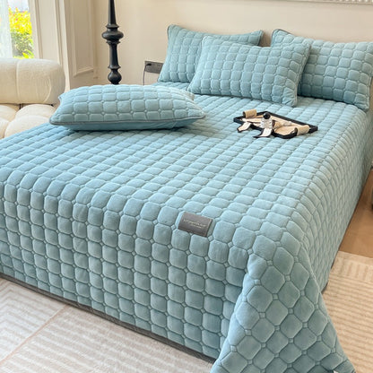 Gewatteerde bedsprei van teddy met blokjesmotief op een tweepersoonsbed - lichtblauw
