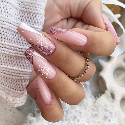 Kerst plaknagels met kerstprint, opgeplakt op een hand - roze glitter met sneeuwvlok