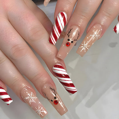 Kerst plaknagels met kerstprint, opgeplakt op een hand - zuurstok met rendier