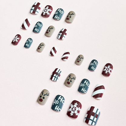 Kerst plaknagels met kerstprint, opgeplakt op een hand