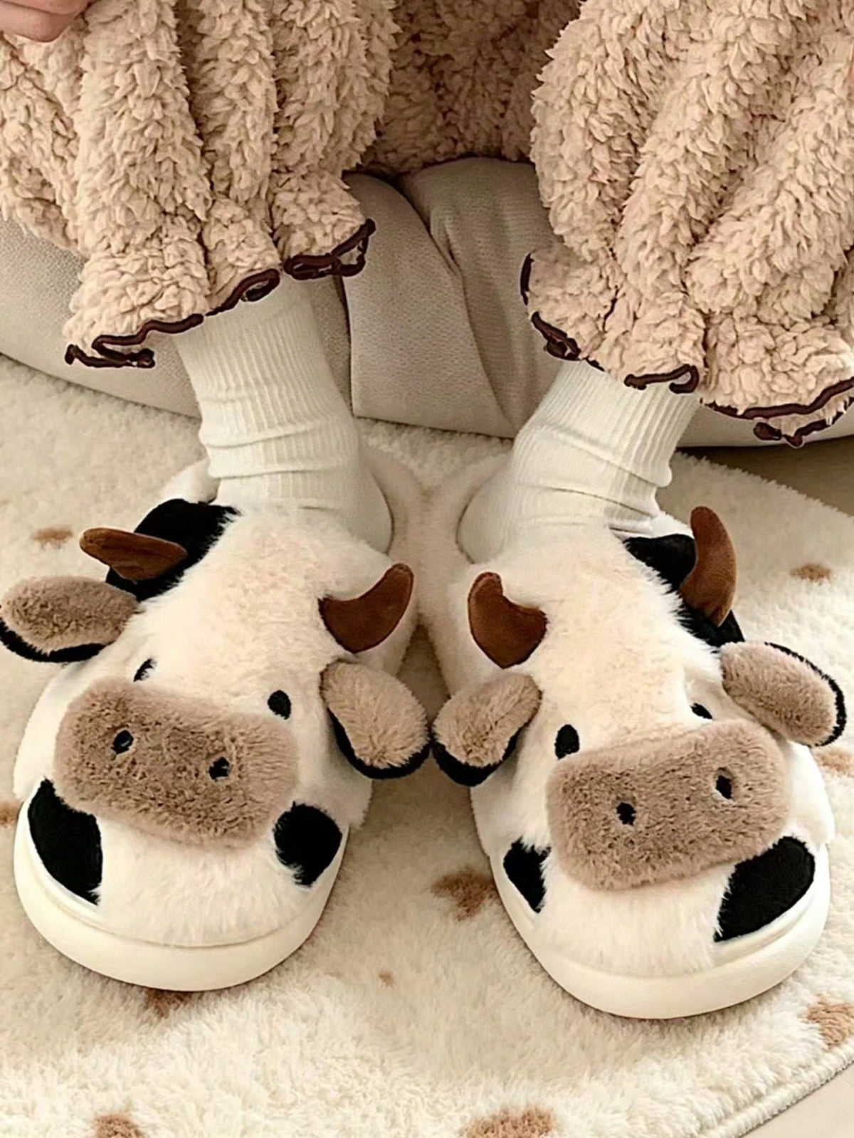 Koe pantoffels van pluche met hoorntjes, oren en snuit op de neus en vlekken op de zijkant - zwart-wit