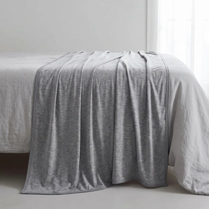Dubbelzijdige koeldeken over een opgemaakt bed
