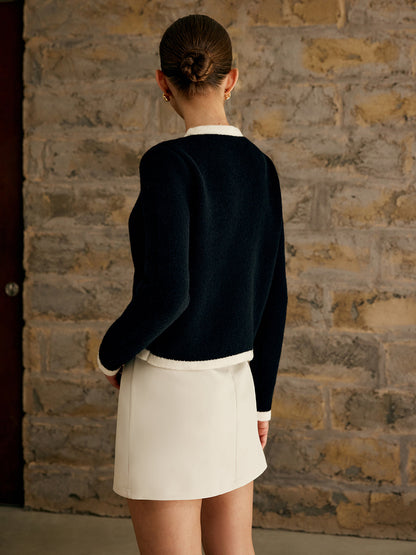Kort damesvest met ronde hals, contrastboorden en goudkleurige knopen