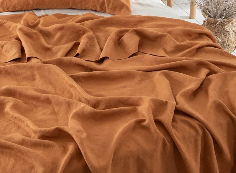 Luchtig geweven laken met gewassen look op een bed - roest