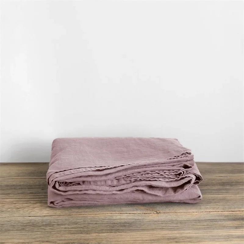 Luchtig geweven laken met gewassen look op een bed - oudroze