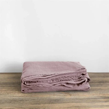 Luchtig geweven laken met gewassen look op een bed - oudroze