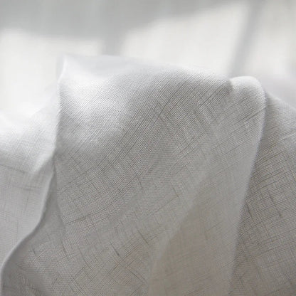 Luchtig geweven laken met gewassen look op een bed - wit