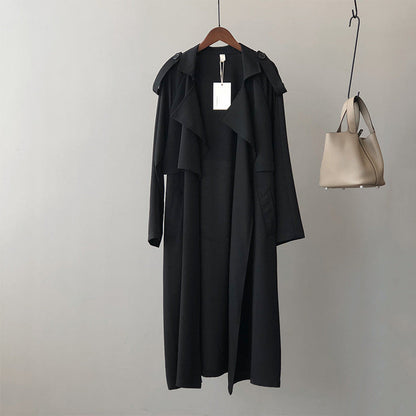 Lange trenchcoat voor dames met brede vallende revers en strikceintuur - zwart