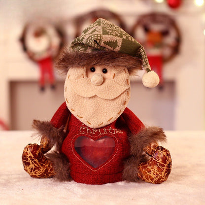 Zittend pluche kerstfiguur met muts, sjaal en een hartvormig venster in het lijfje - kerstman