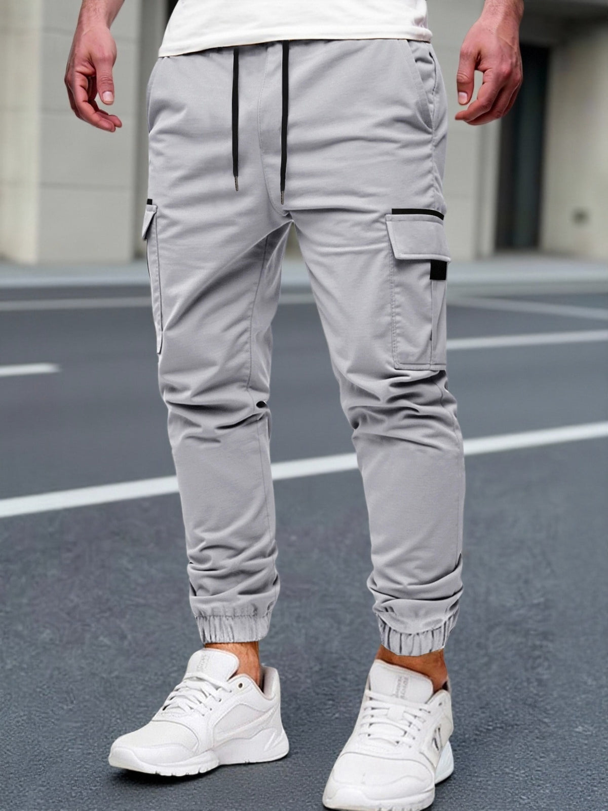 Cargo joggingbroek voor heren met trekkoord, klepzakken op de dijen en boord om de enkel - lichtgrijs