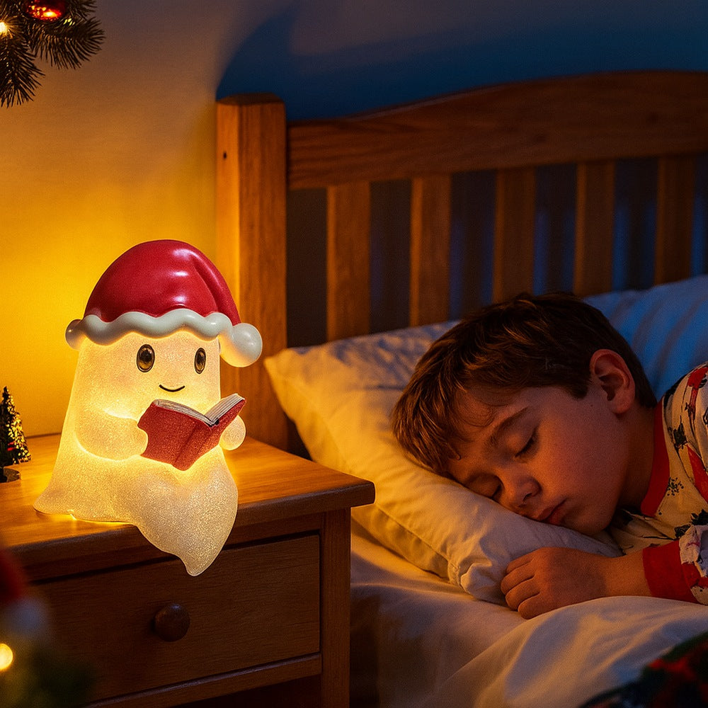 Wit spooklampje met rode kerstmuts en belletje dat een rood boek vasthoudt en warm geel oplicht