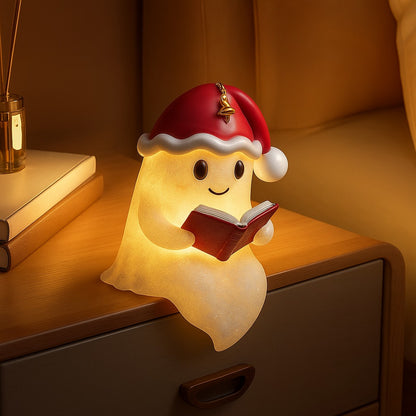 Wit spooklampje met rode kerstmuts en belletje dat een rood boek vasthoudt en warm geel oplicht