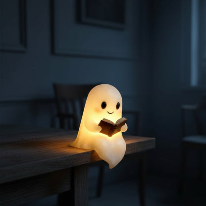 Wit spooklampje met zwarte oogjes en roze wangen dat een open bruin boek vasthoudt en warm geel oplicht