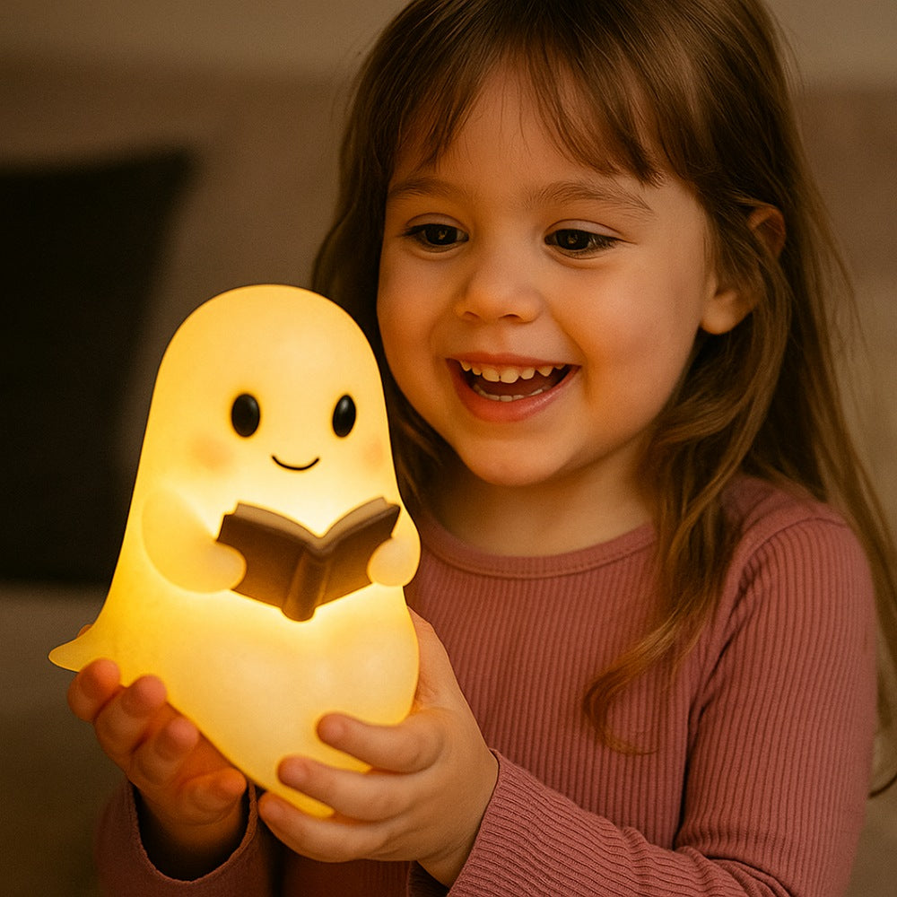 Wit spooklampje met zwarte oogjes en roze wangen dat een open bruin boek vasthoudt en warm geel oplicht