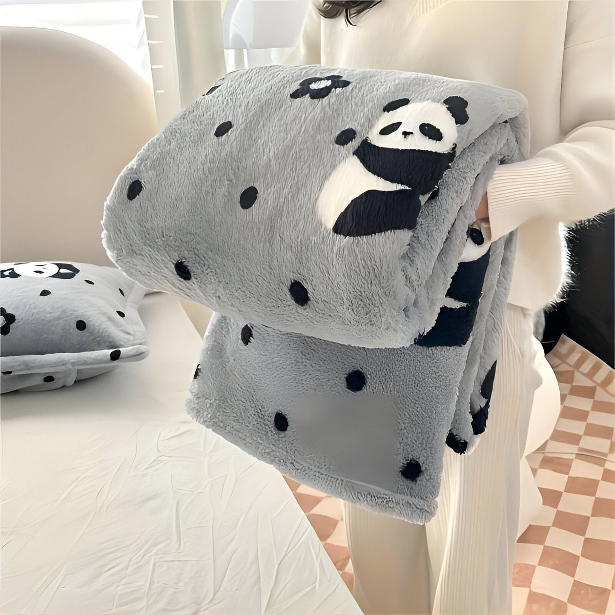 Teddy fleece deken met dambordpatroon, opgevouwen in de armen - grijs met panda's