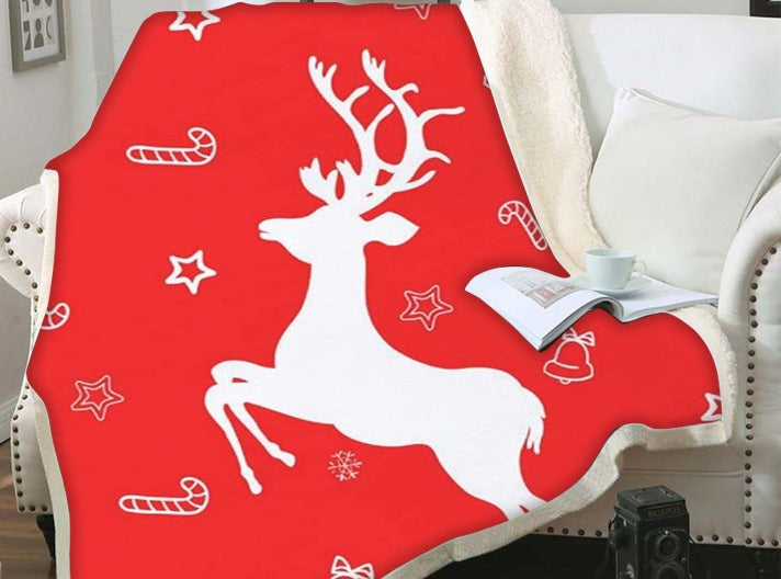 Kerstplaid met teddy achterkant en kerstprint over een fauteuil - rood met wit rendier