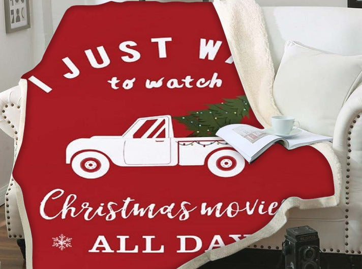 Kerstplaid met teddy achterkant en kerstprint over een fauteuil - rood met pick-up en kerstfilmtekst