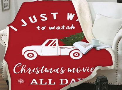 Kerstplaid met teddy achterkant en kerstprint over een fauteuil - rood met pick-up en kerstfilmtekst