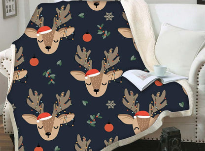 Kerstplaid met teddy achterkant en kerstprint over een fauteuil - donkerblauw met rendierkopjes