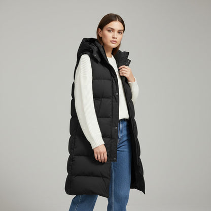 Lange mouwloze damesbodywarmer met gewatteerde capuchon en rits